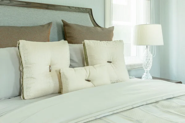 Cozy bedroom interior with white pillows and reading lamp on bedside table — Stock Photo, Image