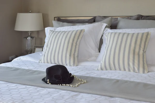 Modern yatak odası eritli yastık ve yatak üzerinde siyah şapka ile — Stok fotoğraf
