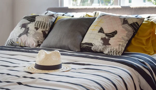 siyah ve beyaz desenli yatakta evde antika hasır şapka