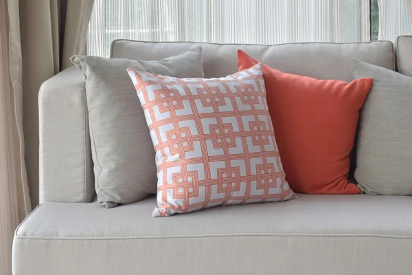 Patrón chino en naranja con almohadas naranjas profundas y grises en un sofá gris claro — Foto de Stock