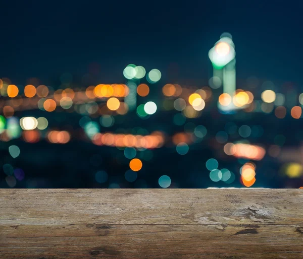 Wooden table top with blurred abstract background of bangkok night lights downtown city view with bokeh — Stock Photo, Image