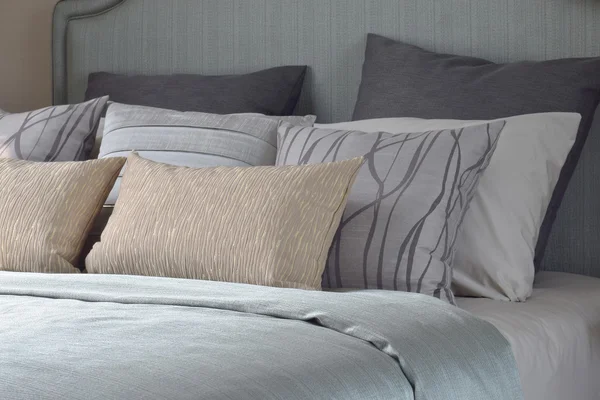 Travesseiros com textura e padrão na cama com cobertor de cetim azul claro — Fotografia de Stock