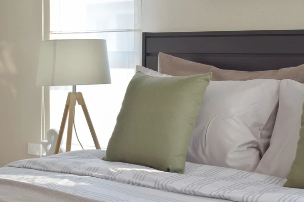 现代居室室内绿色枕头和装饰木灯在床边的桌子上 — 图库照片