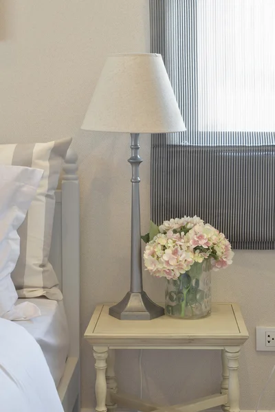 Interiér útulné ložnice s polštáři a na nočním stolku lampa na čtení — Stock fotografie