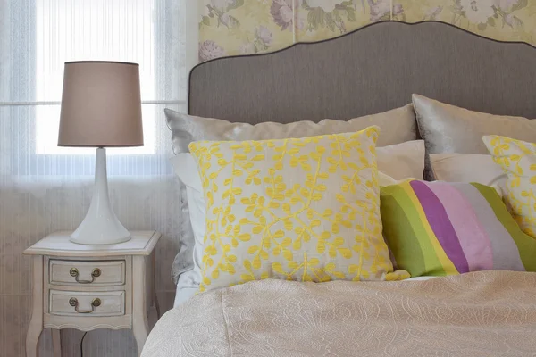 Aconchegante quarto interior com travesseiro colorido e lâmpada de mesa de cabeceira — Fotografia de Stock