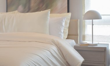 Yastıklar ve okuma lâmbası başucundaki ile rahat yatak odası iç