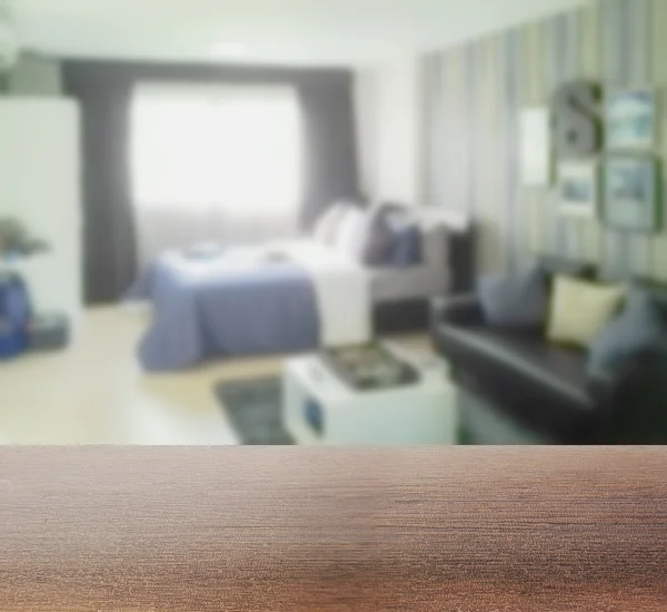 Tampo de mesa de madeira com borrão de fundo borrado quarto com sofá — Fotografia de Stock