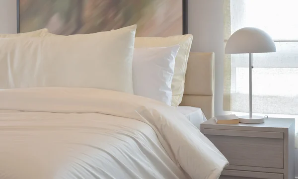 Yastıklar ve okuma lâmbası başucundaki ile rahat yatak odası iç