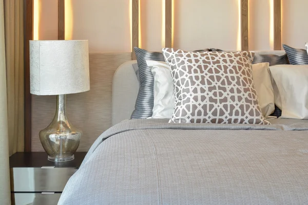 Desain interior kamar tidur bergaya dengan bantal coklat di tempat tidur dan lampu meja dekoratif . — Stok Foto