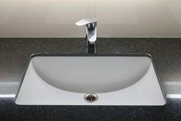 Modern style faucet with black granite counter top Stock Image