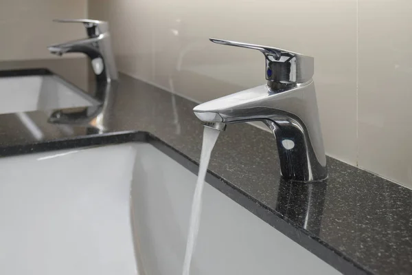 Grifo de estilo moderno con lavabo bajo mostrador en el baño — Foto de Stock