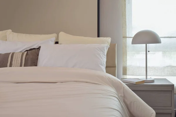 Acogedor dormitorio interior con almohadas y lámpara de lectura en la mesita de noche —  Fotos de Stock
