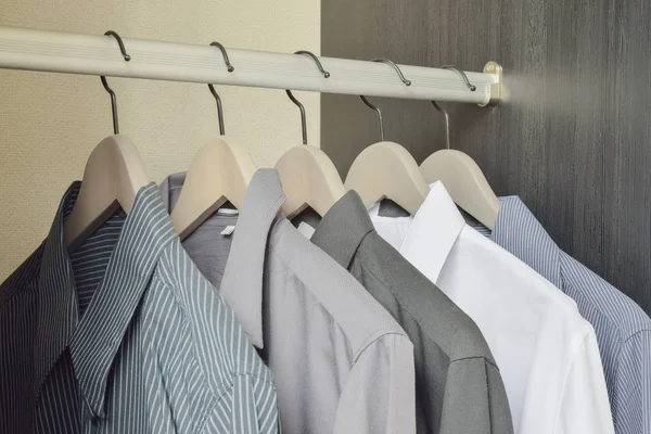 Linha de camisas pretas e brancas penduradas no guarda-roupa — Fotografia de Stock