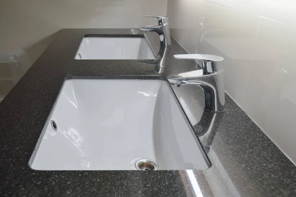 Grifo de estilo moderno con lavabo bajo mostrador en el baño — Foto de Stock