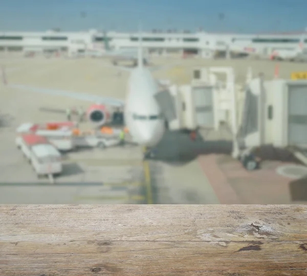 Дерев'яна стільниця з розмитістю літаків і зоною завантаження в аеропорту — стокове фото