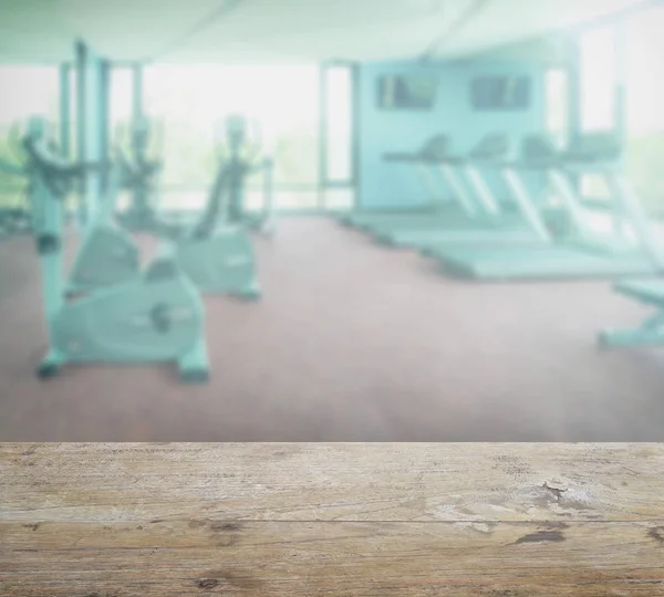 Дерев'яна стільниця з розмиттям внутрішнього фону фітнес-кімнати — стокове фото