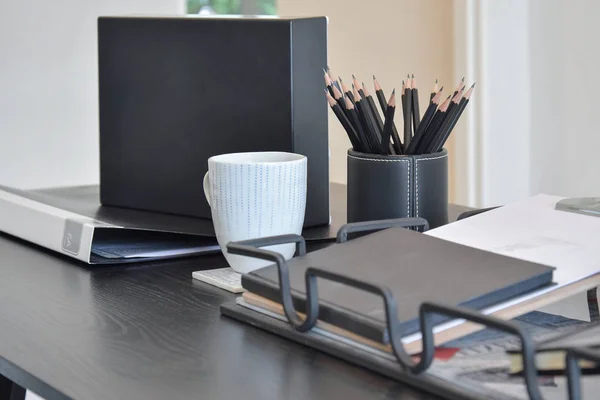 work table with book,pencils and cup of coffee and in a home