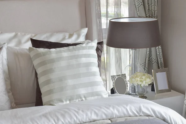 Сучасний інтер'єр спальні з зеленою смугастою подушкою на ліжку і тумбочці настільна лампа вдома — стокове фото