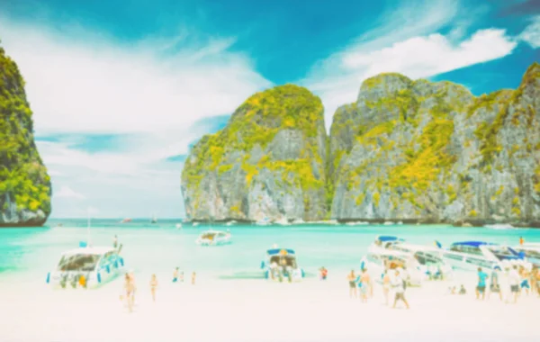 Turista borrosa en la playa de arena blanca en la bahía de maya, phi phi leh isla, tailandia - tono vintage — Foto de Stock