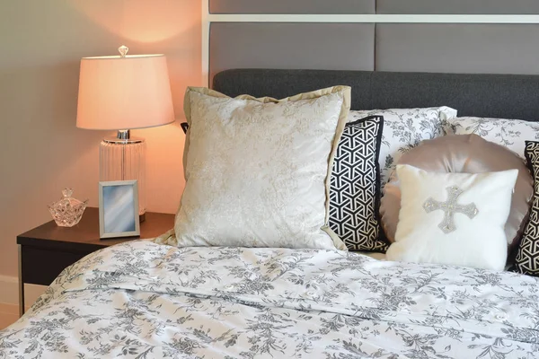 Розкішний інтер'єр спальні з подушками з квіткового візерунка та декоративною настільною лампою — стокове фото