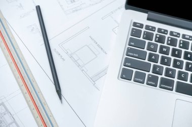 black pencil and computer laptop on architectural drawing paper for construction clipart