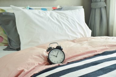 Derma yatak takımları ile yatakta siyah çalar saat