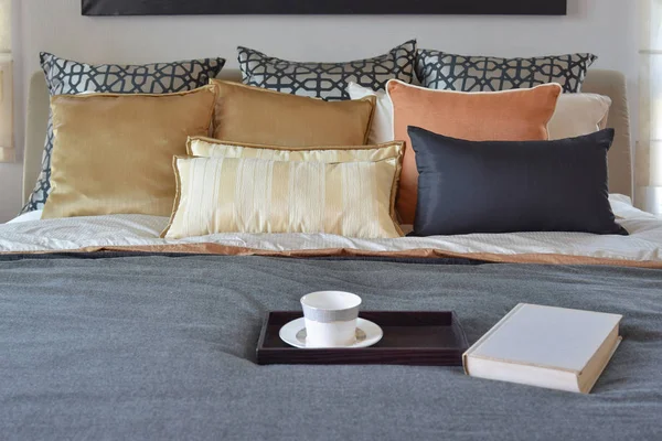 Nowoczesna sypialnia wnętrza z filiżanka na dekoracyjne drewniana taca i białą księgę na łóżku — Zdjęcie stockowe