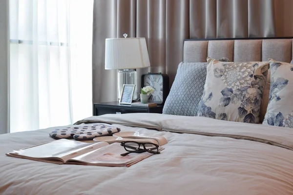 çiçek desenli yastık yatak ve dekoratif masa lambası ile şık yatak odası iç tasarım.