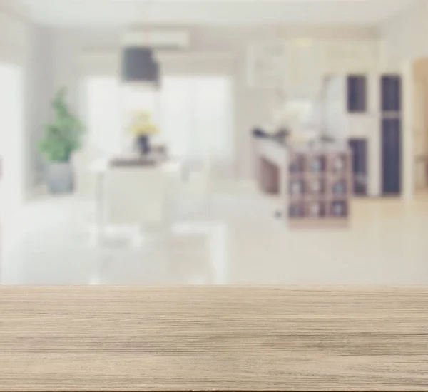 Wooden table top with blur image of modern dining room interior — Stock Photo, Image