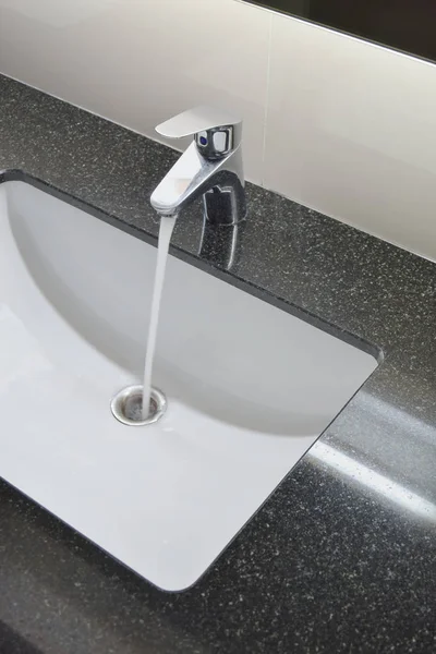 Vattenkranen och under counter tvättställ med svart granit topp — Stockfoto