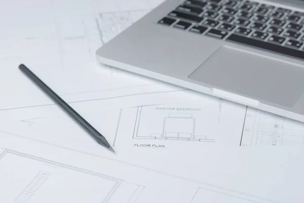 Black pencil and computer laptop on architectural drawing paper for construction — Stock Photo, Image