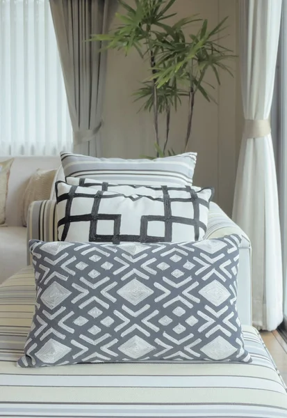 Almohadas de patrón gráfico en sofá a rayas en la sala de estar moderna — Foto de Stock