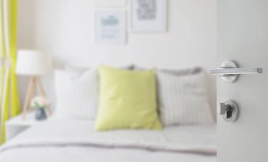 yatakta yeşil yastık ile modern yatak odası beyaz kapı açıldı