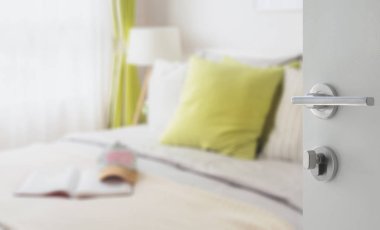 yatakta yeşil yastık ile modern yatak odası beyaz kapı açıldı