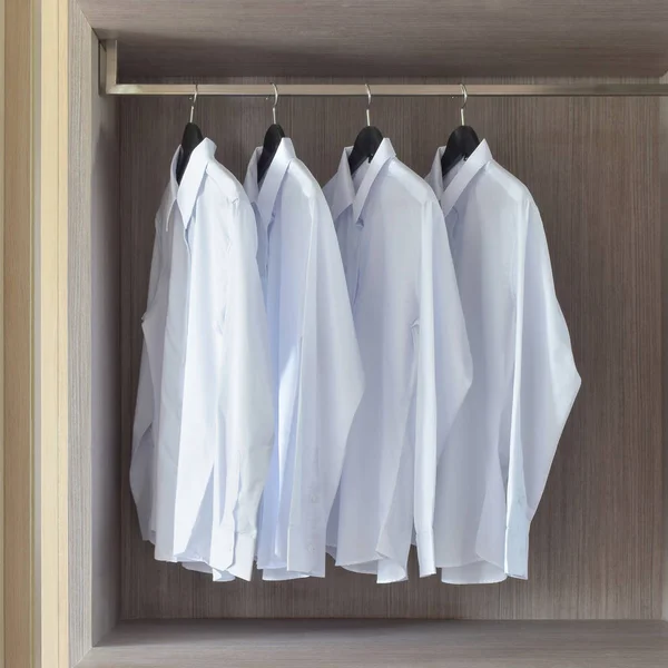 Klassiska vita skjortor i varmt trä garderob — Stockfoto