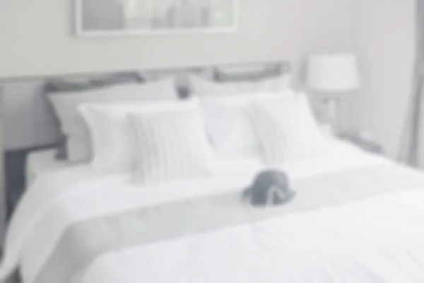 Размытая современная спальня с полосатыми подушками на кровати для заднего плана — стоковое фото