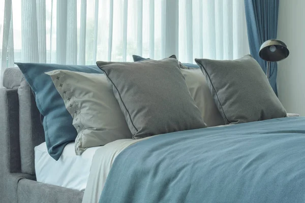 Gray and deep blue pillows setting on bed in deep blue color scheme bedding — Stock Photo, Image