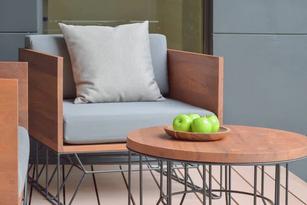 Bandeja de manzana sobre mesa de madera junto a asiento de madera con cojín exterior — Foto de Stock