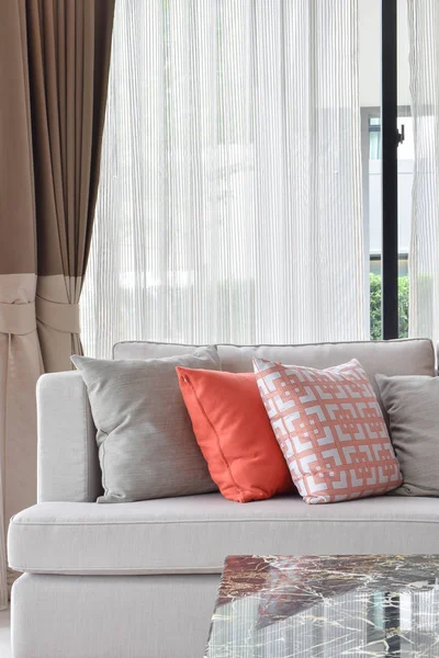 Almohadas anaranjadas y grises en sofá beige en la sala de estar — Foto de Stock