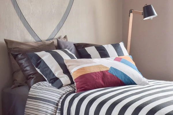 Разноцветные полосатые постельные принадлежности в светло-коричневой спальне — стоковое фото