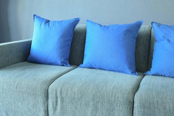 Almohadas de color azul en el sofá azul claro con pared azul —  Fotos de Stock