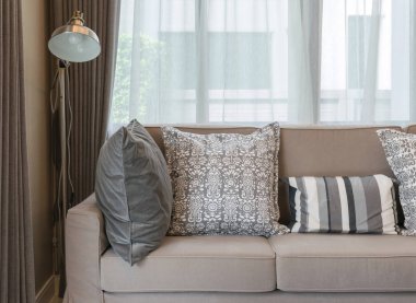 kahverengi kanepe ve gri desenli yastıklar oturma odası