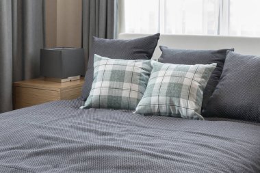 yatak odası iç tasarım ile işaretli yeşil yastık gri yatak ve dekoratif masa lambası.