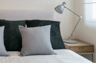 beyaz yatak ve dekoratif masa lambası gri yastık ile yatak odası iç tasarım.