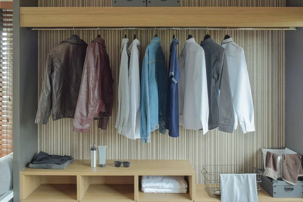 Jaquetas e camisas no guarda-roupa de cor marrom — Fotografia de Stock