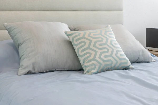 Camera da letto moderna con comodi cuscini morbidi sul letto azzurro — Foto Stock