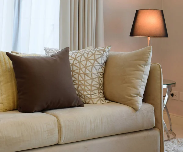 Solidne brązowe tweed sofa z szary wzorzyste poduszki i lampa — Zdjęcie stockowe