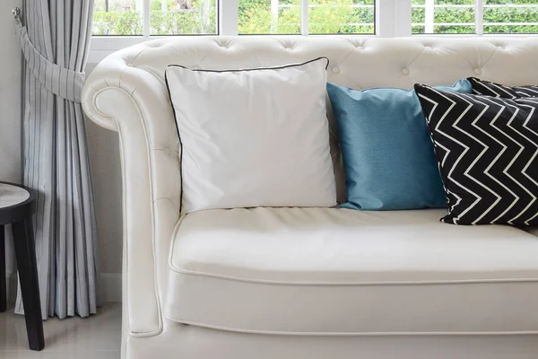 Almohadas blancas y azules en un sofá de cuero blanco en la sala de estar vintage —  Fotos de Stock