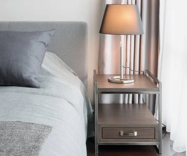 Elegante dormitorio de diseño interior con lámpara de mesa decorativa y almohadas grises en la cama —  Fotos de Stock