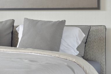 Koyu gri ve beyaz yastıklar yatakta rahat battaniye ile ayarlama